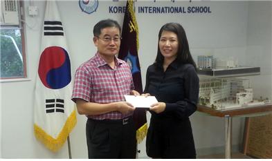 <한국국제학교 학부모 류치하 씨(사진 오른쪽, 현 한인여성회 부회장)가 발전기금으로 서재철 교장(왼쪽)에게  10만 홍콩달러를 기탁했다. >  