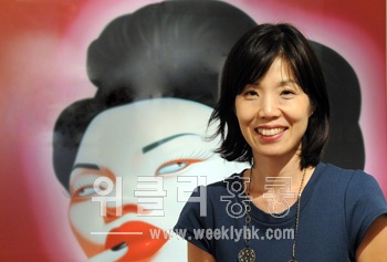 ▲ 서울옥션 이소영 홍콩법인장이 Contemporary Art Today 전시회를 소개하며 펑정지예 작가의 Chinese Portrait No. 37(2008년) 작품 앞에서 포즈를 취하고 있다