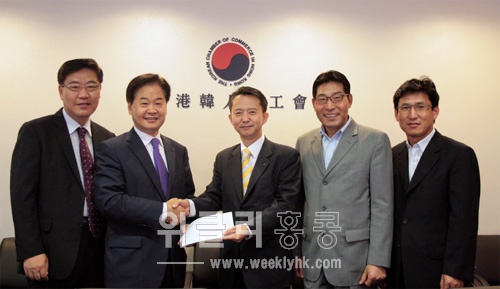신한은행홍콩 김진형 지점장(중간)이 신홍우 상공회장(왼쪽에서 두 번째)에게 회관 건립기금을 전달하고 있다.