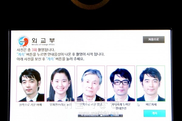 여권촬영용 카메라 앞에 앉으면 사진과 함께 음성안내가 시작된다. 모든 과정은 터치스크린으로 작동 가능하다.
