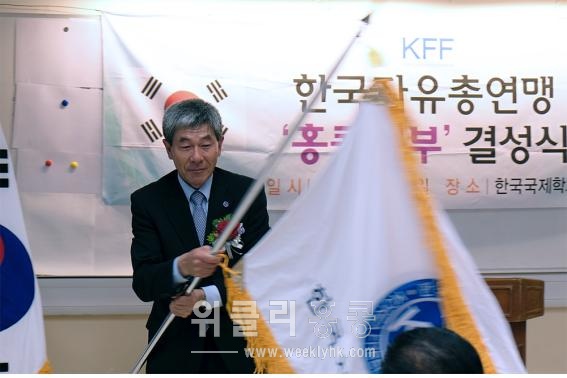 <13일 열린 한국자유총연맹 홍콩지부 결성식에서 김구환 지회장이 허준영 총재로부터 연맹기를 전수받고 홍콩교민들의 권익신장과 국가정체성 확립을 위해 노력하겠다는 각오를 다지며 기를 흔들고 있다. >