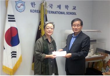 <홍콩한인회 장은명 부회장은 지난 7일 KIS 서재철 교장에게 학교 발전기금으로 10만 홍콩달러를 전달했다. >