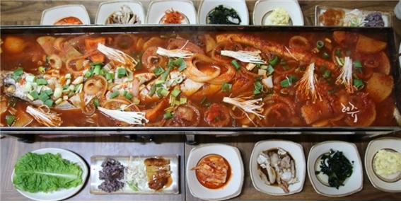 △ 점보철판 통갈치찜: 약 1미터가량 되는 제주은갈치 한 마리가 통째로 들어가 있다. 무와 감자, 그리고 가래떡이 들어 가 있다. 전복도 들어가 있다. 제주은갈치의 고소한 맛이 매콤한 고추장과 고춧가루 소스와 너무 잘 어우러졌다. (가격 : 원화 10만원 5-7인용)